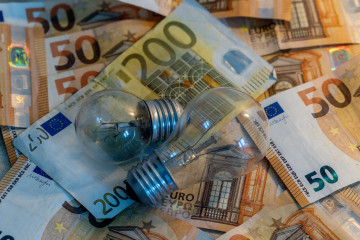 Archivo - Dos bombillas sobre billetes