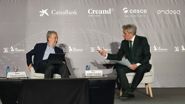 El presidente de CaixaBank, Tomás Muniesa, y el periodista Josep Puigbó.