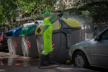 Archivo - Un operario de limpieza del servicio municipal desinfecta un contenedor amarillo de basura tras la reincorporación de 1.000 operarios de limpieza durante la fase 0 de la desescalada en la c