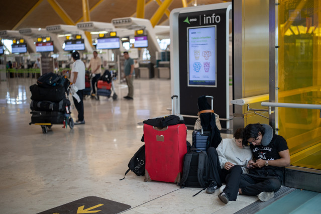 Dos personas con maletas en el aeropuerto Adolfo Suárez Madrid-Barajas durante la primera operación salida del verano 2025, a 27 de junio de 2025, en Madrid (España).