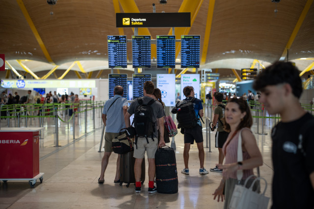 Varias personas observan las pantallas de información en el aeropuerto Adolfo Suárez Madrid-Barajas durante la primera operación salida del verano 2025, a 27 de junio de 2025, en Madrid (España).