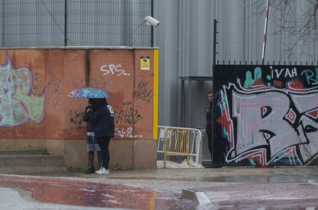 Archivo - Dos migrantes se protegen de la lluvia con un paraguas en las inmediaciones del centro de Emergencia, Acogida y Derivación en el Acuartelamiento 'Primo de Rivera', donde se alojan migrantes procedentes de Canarias, a 19 de enero de 2024, en Alca