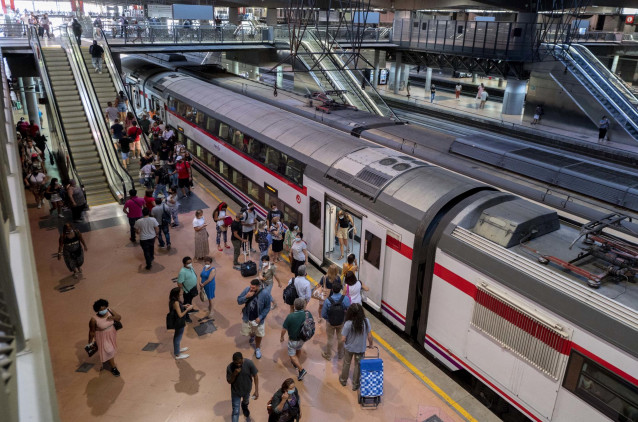 Archivo - Varios viajeros suben al tren en los andenes de cercanías de la estación de tren de Atocha