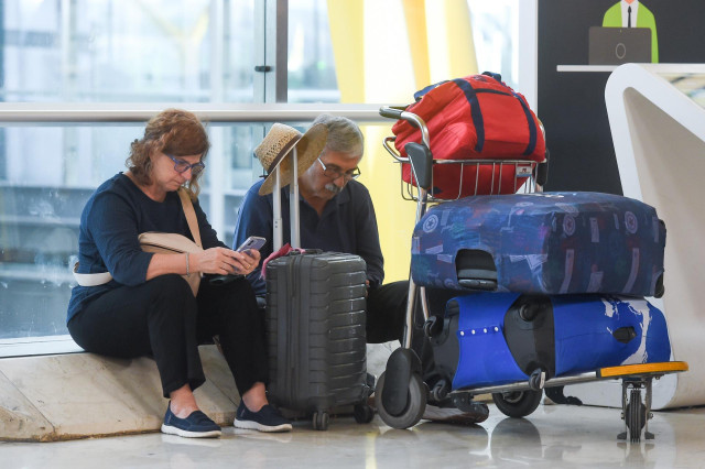 Pasajeros esperan en la entrada de la Terminal 4 de Barajas.