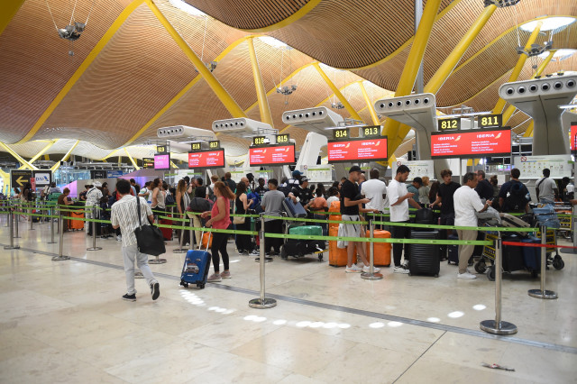 Pasajeros esperan en la entrada de la Terminal 4 de Barajas, en Madrid (España).