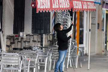 Archivo - Una camarera levanta el toldo de un bar, a 12 de enero de 2024, en Madrid (España).
