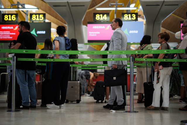 Archivo - Varios pasajeros en una fila de Iberia en la Terminal T4 del Aeropuerto Adolfo Suárez-Madrid Barajas, en Madrid (España).