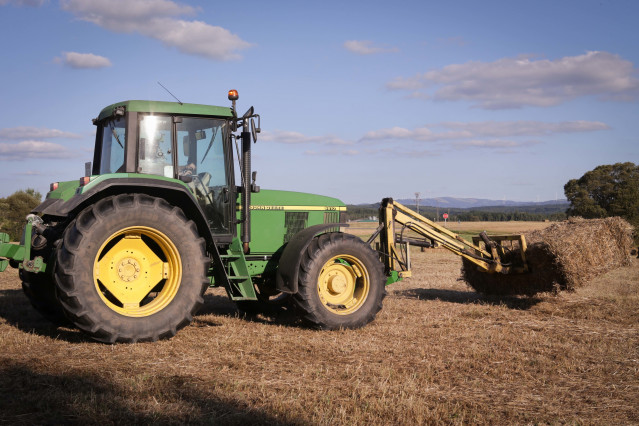 Archivo - Un tractor durante la recogida de trigo