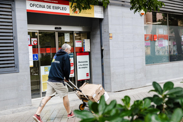 Archivo - Un repartidor pasa por la oficina del paro