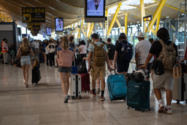 Archivo - Varias personas con maletas en el aeropuerto Adolfo Suárez Madrid-Barajas.