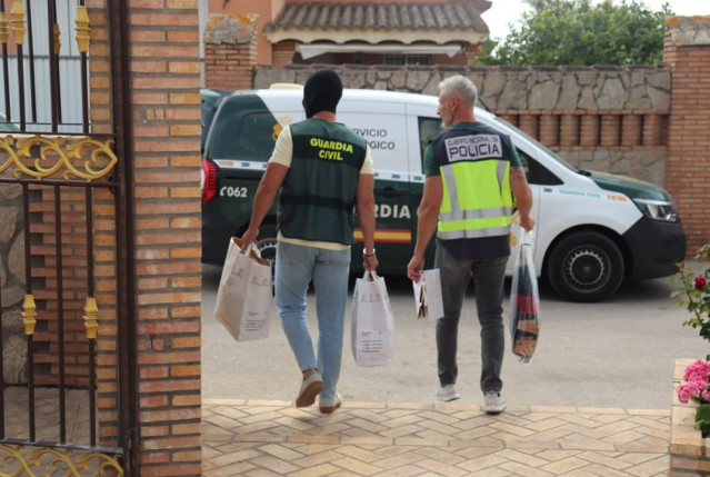 Archivo - Dos agentes de la Guardia Civil y la Policía Nacional durante un operativo en Cádiz.