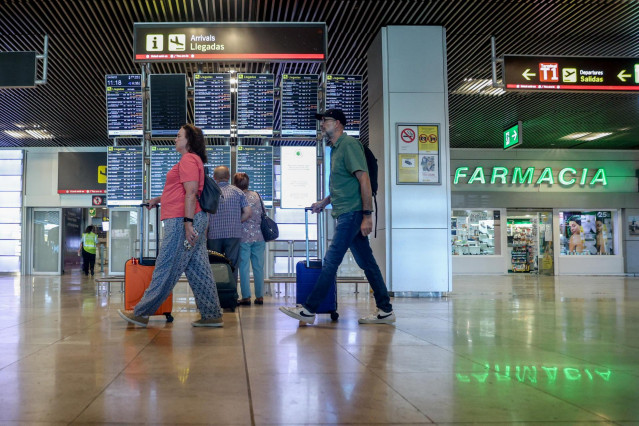Archivo - Varias personas con maletas en el aeropuerto Adolfo Suárez-Madrid Barajas.