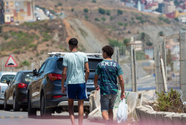 Dos migrantes pasean por la calle.- Archivo