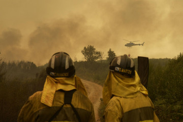 Extinción del fuego en la carretera de acceso a la población de Cualedro.
