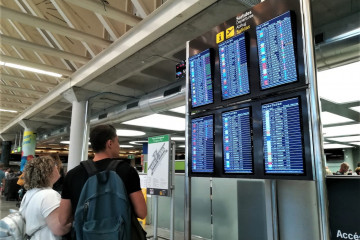 Archivo - Turistas comprueban la información de las pantallas de embarque en el aeropuerto de Palma. Recurso