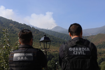 Dos agentes de la Guardia Civil observan el incendio, a 22 de agosto de 2025, en Degaña, Asturias (España). Este viernes se registran ocho incendios forestales en el Principado de Asturias, según l