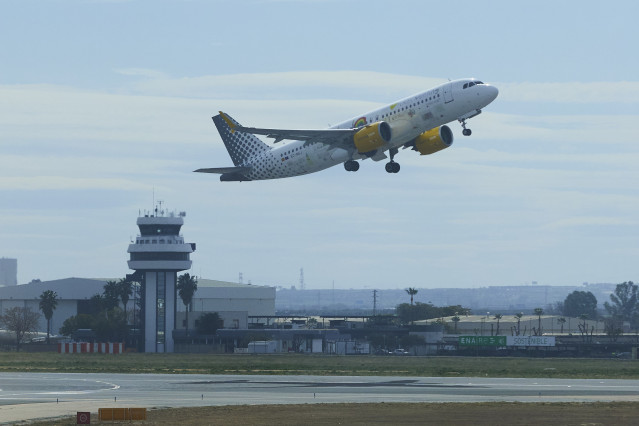 Archivo - Un avión despega y al fondo la torre de control