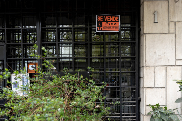 Archivo - Vista de un cartel de 'Se vende' piso en un edificio de viviendas