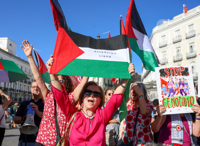 Varias personas con banderas de Palestina y pancartas piden el 