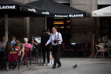 Archivo - Foto de archivo de un camarero sostiene una bandeja en la plaza Real de Barcelona.