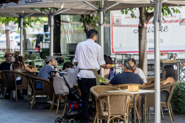 Archivo - Un camarero atendiendo una mesa en una terraza de Madrid