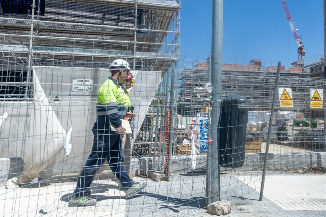 Archivo - Dos obreros trabajan en la construcción de una vivienda nueva, a 29 de julio de 2025, en Madrid (España).