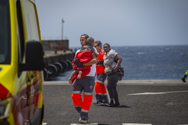 Archivo - Un miembro de Salvamento Marítimo coge en brazos a un bebé migrante a su llegada al  puerto de La Restinga.