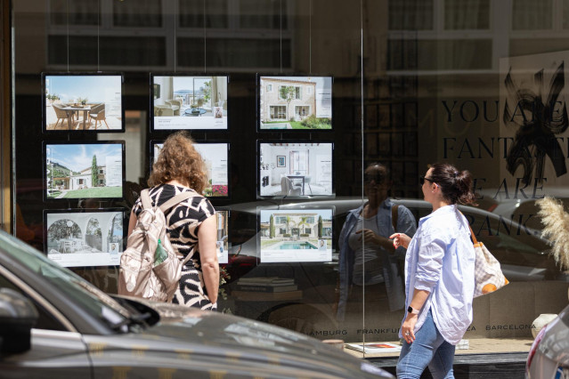 Archivo - Dos personas observan los anuncios de viviendas en venta en una inmobiliaria, a 15 de abril de 2024, en Palma de Mallorca, Mallorca, Baleares (España).