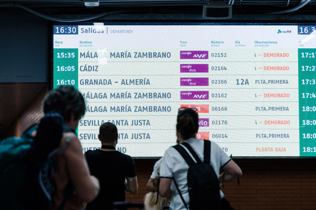 Archivo - Varias personas observan una pantalla informativa en la Estación de Madrid - Puerta de Atocha - Almudena Grandes, a 30 de agosto de 2025, en Madrid (España). El tráfico ferroviario entre Madrid y Andalucía se encuentra cortado por un incendio en