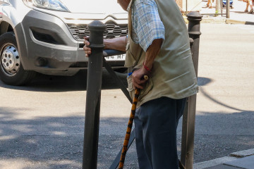 Archivo - Persona mayor caminando por la calle ayudada por un bastón, a 15 de julio de 2025, en Madrid (España).