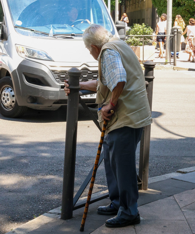 Archivo - Persona mayor caminando por la calle ayudada por un bastón, a 15 de julio de 2025, en Madrid (España).