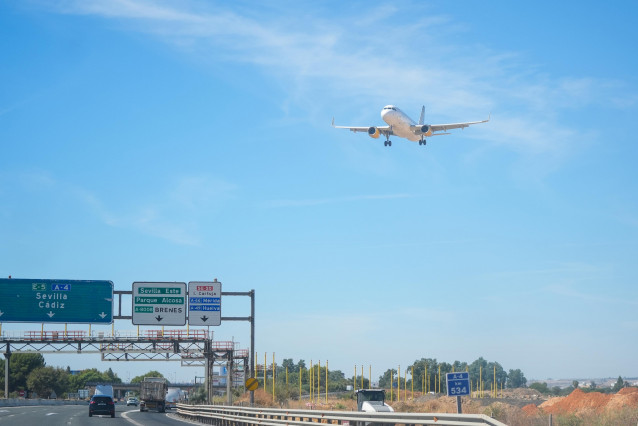 Un avión sobrevuela la autovía A-4 antes de aterrizar en el aeropuerto de Sevilla.