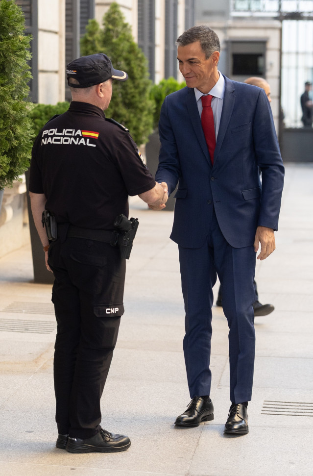 Un agente de Policía Nacional saluda al presidente del Gobierno, Pedro Sánchez, a su llegada a una sesión de control en el Congreso de los Diputados, a 17 de septiembre de 2025, en Madrid (España).