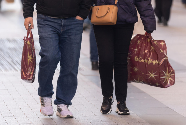 Archivo - Dos personas llevan bolsas con regalos para Reyes, a 5 de enero de 2024, en Madrid (España).