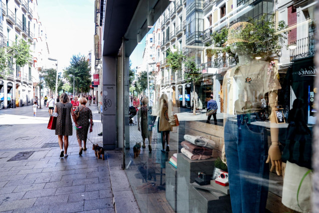 Archivo - Varias personas pasan por delante de un escaparate de una tienda de ropa