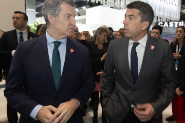 Archivo - El presidente del Partido Popular, Alberto Núñez Feijóo (i) y el presidente de la Generalitat valenciana, Carlos Mazón (d), conversan en el estand de la Comunidad Valenciana, durante su 