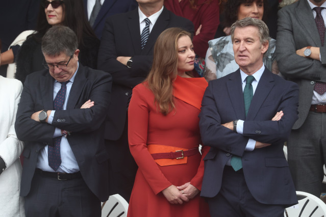 El presidente del Partido Popular, Alberto Núñez Feijóo (d), y la portavoz del PP en el Congreso, Ester Muñoz (c), durante el acto solemne de homenaje a la bandera nacional y desfile militar por el 12 de octubre, Día de la Hispanidad, en la Plaza de Cánov