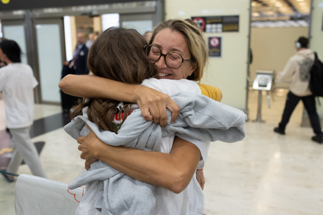 La activista Reyes Rigo abraza a una amiga a su llegada al aeropuerto Adolfo Suárez Madrid-Barajas, a 13 de octubre de 2025, en Madrid (España).