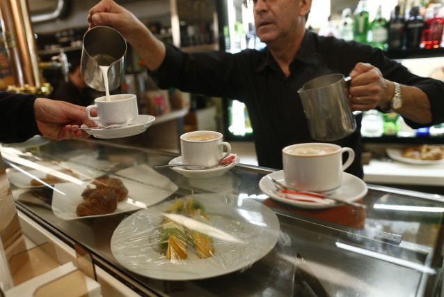 Archivo - Camarero poniendo cafés en un bar