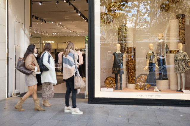 Archivo - Varias mujer miran la entrada de una tienda