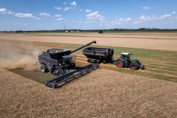This image, taken during the 2024 AGCO Tech Day, shows PTx Trimble’s OutRun solution in action: an autonomous Fendt tractor pulls a grain cart alongside an IDEAL combine during offloading. AGCO’s 