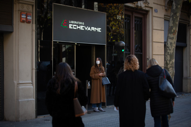 Archivo - Varias personas hacen cola para hacerse test y otras pruebas de covid, en el laboratorio Echevarne, en una imagen de archivo.