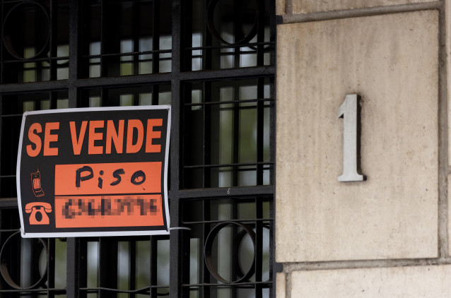 Archivo - Cartel de 'Se vende' en un portal de un edificio'.
