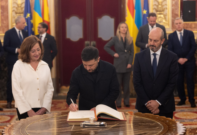 El presidente de Ucrania, Volodimir Zelenski (c), firma el libro de Honor del Congreso, junto a la presidenta del Congreso, Francina Armengol, y con el presidente del Senado, Pedro Rollán (d), en el Congreso