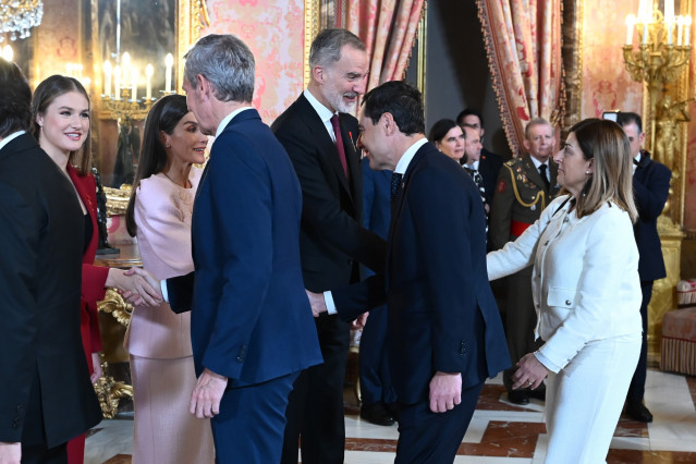 El rey Felipe VI (3d), saluda a la presidenta de Cantabria, María José Sáenz de Buruaga (d), durante el acto central de conmemoración del 50 aniversario de restauración de la monarquía, este viernes en el palacio Real en Madrid.