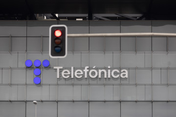 Archivo - Un semáforo en rojo frente a la sede de Telefónica