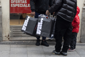 Archivo - Una persona sujeta varias bolsas con compras de Navidad, a 23 de diciembre de 2022, en Madrid (España).