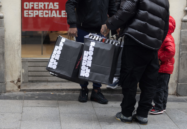 Archivo - Una persona sujeta varias bolsas con compras de Navidad, a 23 de diciembre de 2022, en Madrid (España).