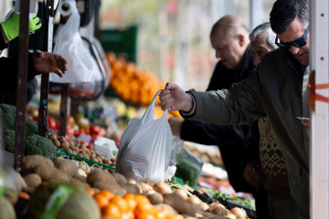 Archivo - Varias personas comprando en un mercado de alimentos