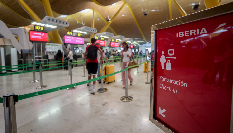 Archivo - Varios pasajeros esperan para obtener sus tarjetas de embarque y facturar su equipaje en el día en que ha dado comienzo una huelga de los tripulantes de cabina de Iberia Express, en la T4 d